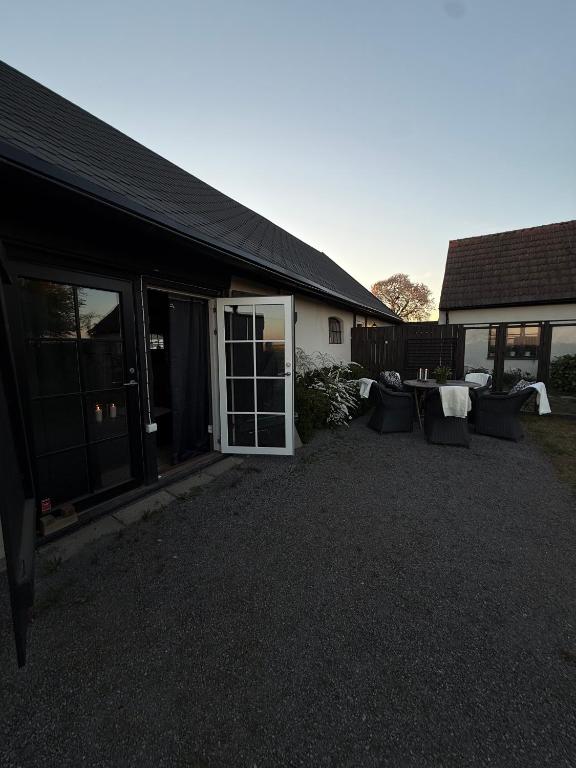 ein Gebäude mit einer Terrasse mit Stühlen davor in der Unterkunft Studio Sommar in Glemmingebro