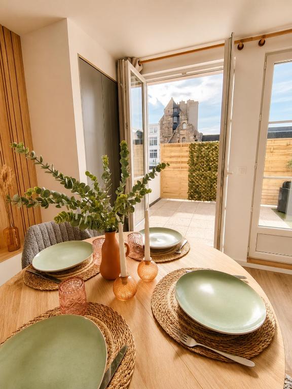 a wooden table with green plates on top of it at Cocon avec terrasse proche plages et centre in Dives-sur-Mer