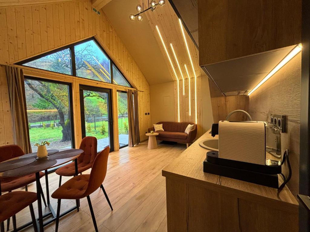 a kitchen and living room with a table and chairs at Flore's Garden in Bran