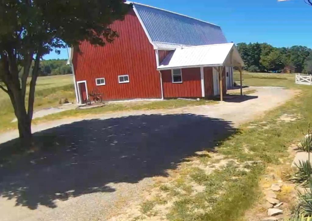 a large red barn with a tree in front of it at The Stable at Windmill Ridge Farm in Fredonia