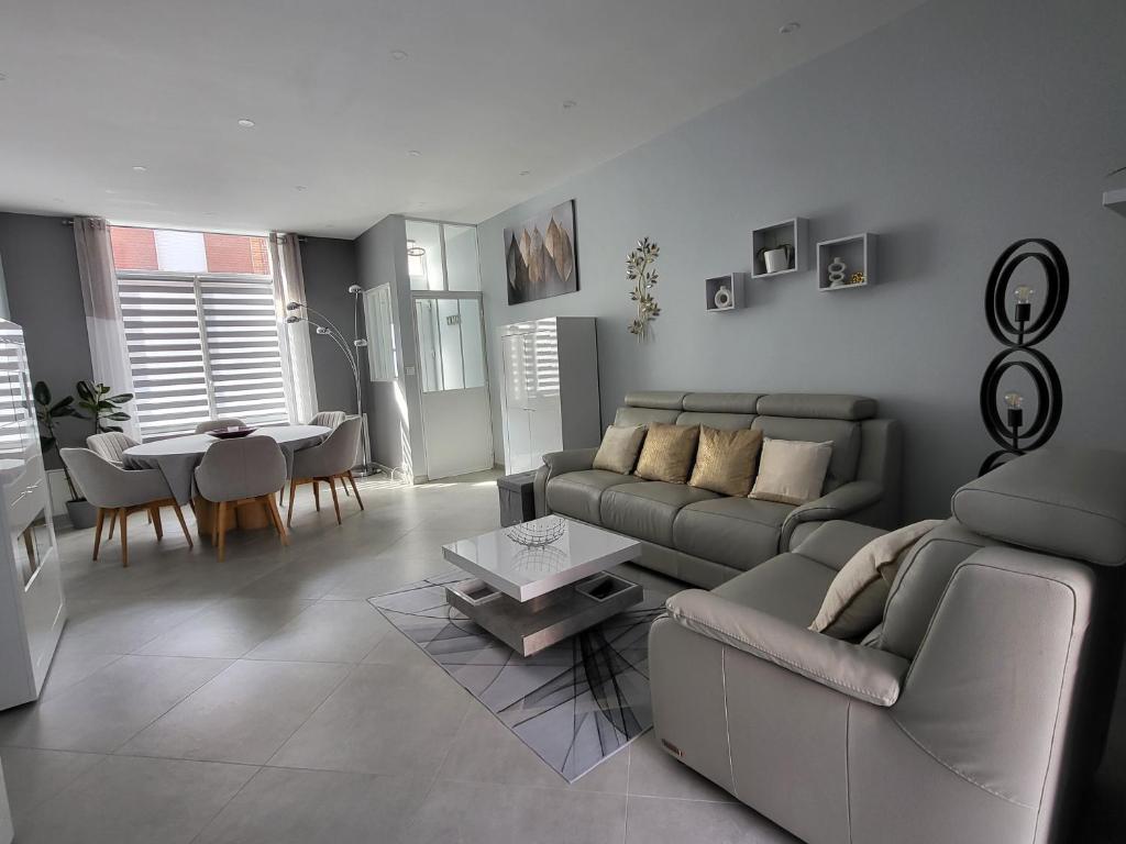 a living room with a couch and a table at Loéli's House in Tourcoing