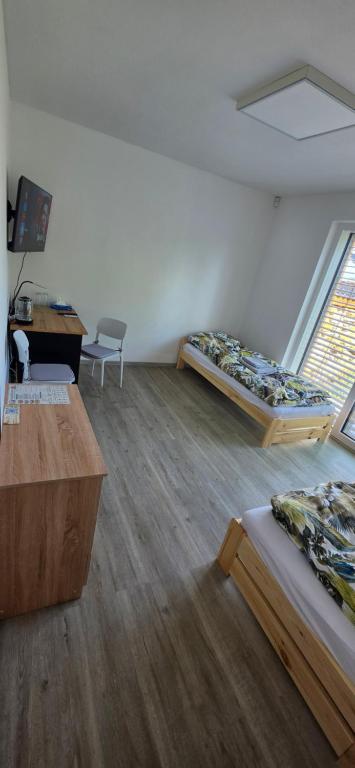 a room with two beds and a desk in it at Útulný klidny pokoj A in Radošovice