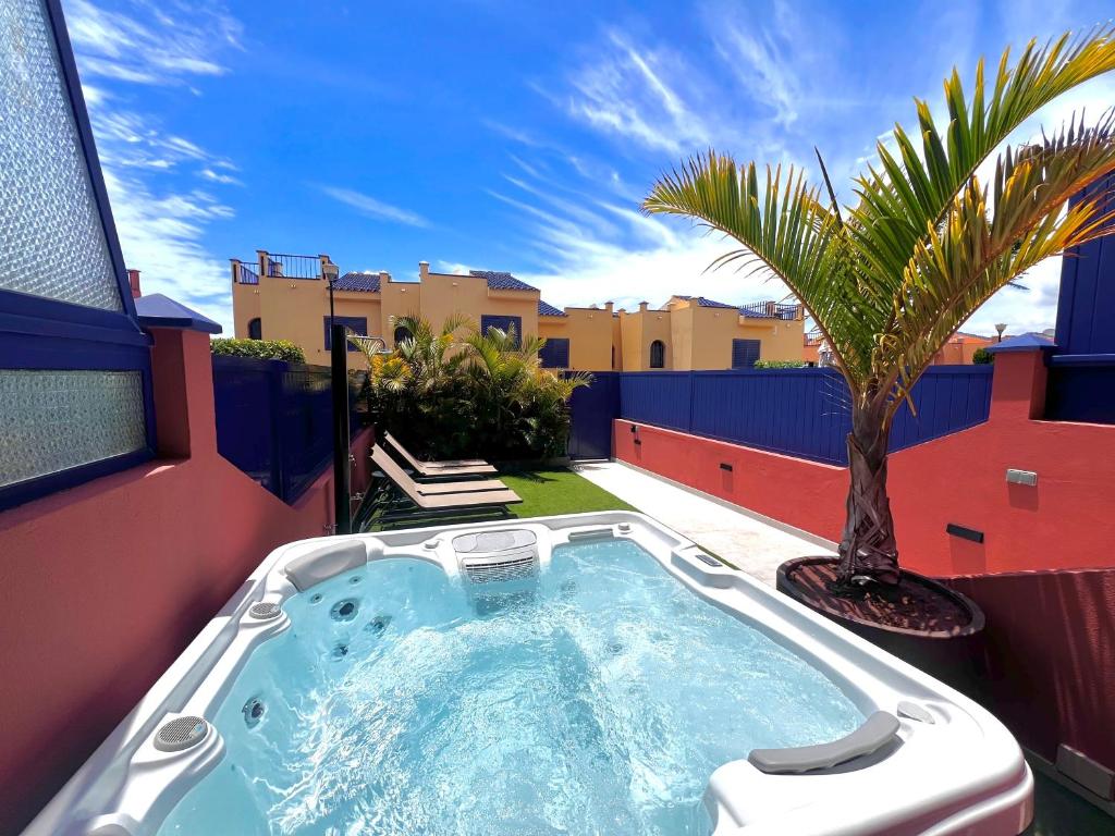 a hot tub on a patio with a palm tree at Holiday home in meloneras with sea views, golf and private jacuzzi in Maspalomas