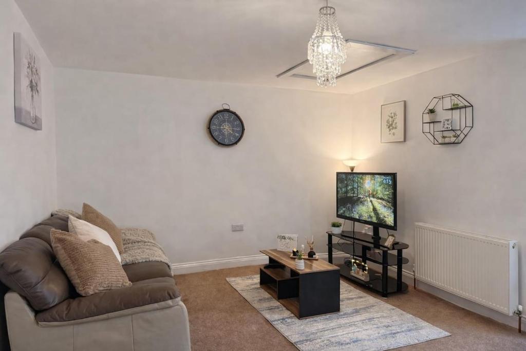 a living room with a couch and a tv at Fully Equipped Homely Heaven in Houghton le Spring