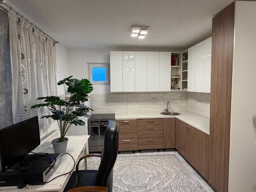 a kitchen with white cabinets and a tv in it at Apartman HODŽIĆ in Sarajevo