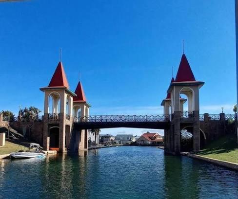 a bridge over a river with two towers on it at Paradise Cove Marina in Jeffreys Bay