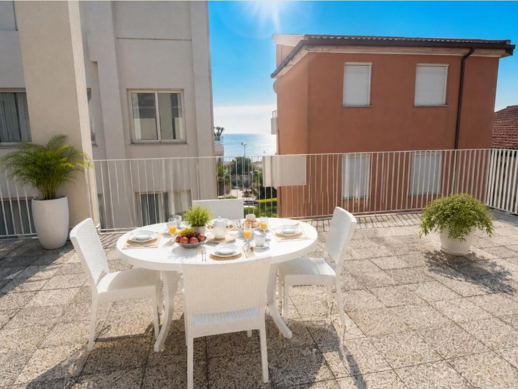 a white table and chairs on a patio at APPARTAMENTI LA CONCHIGLIA in Caorle
