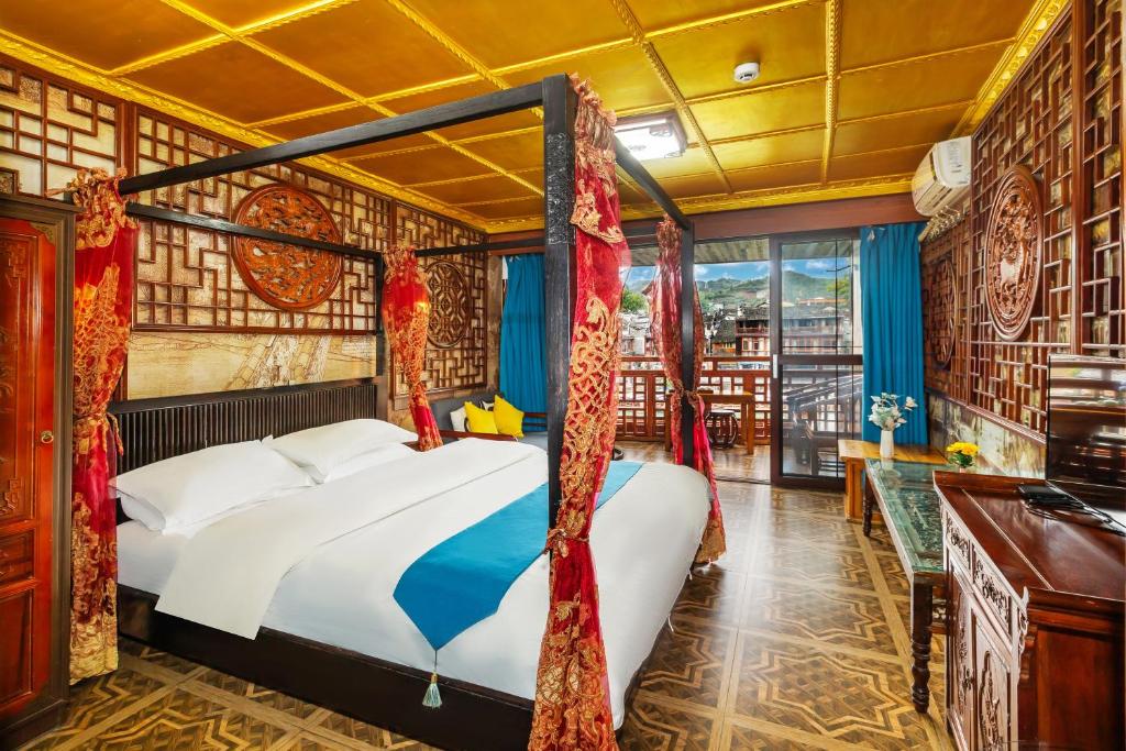 a bedroom with a bed and a desk and a window at LQJ Riverside Guest House in Fenghuang County