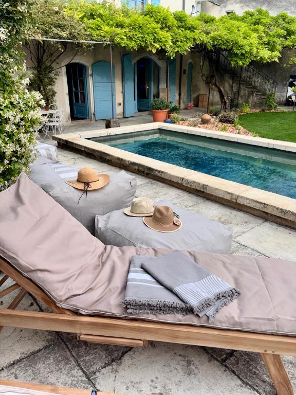 a pool with two lounge chairs and hats on top at Le Jardin Secret in Grignan