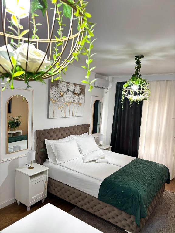a bedroom with a large bed and a chandelier at Apartman Vanila Lux Kragujevac in Kragujevac