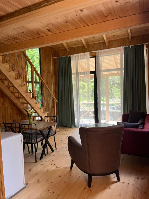 a living room with a staircase and a table and chairs at Babitouli-1 in Niabauri