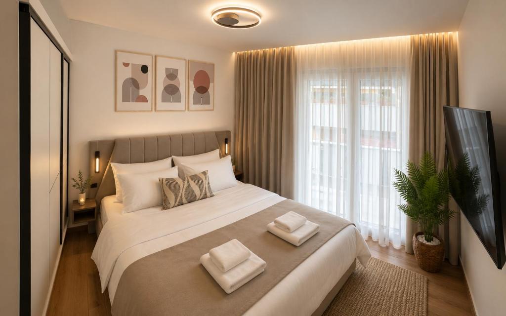a bedroom with a large bed with two pillows on it at Sea & Sun Luxury Apartment in Alexandroupoli