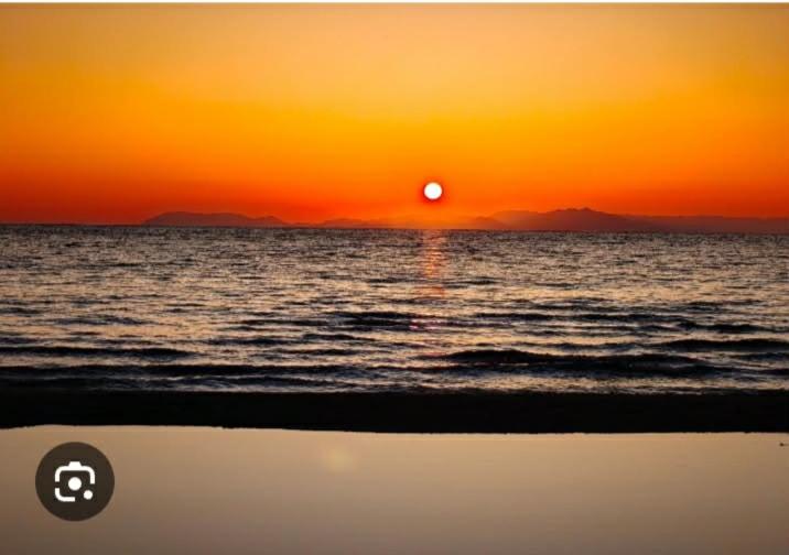 a sunset over the ocean with the sun setting at Victoria's Summer House in Amalias