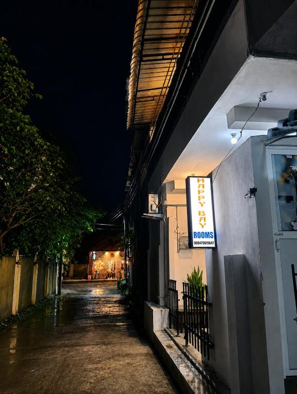 a sign on the side of a building at night at New Happy bay in Arugam Bay