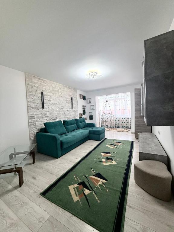 a living room with a blue couch and a green rug at Cozy Urban Apartment in Câmpulung