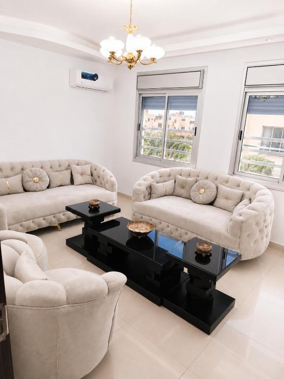 a living room with two couches and a coffee table at Spacious Apartment in Amman