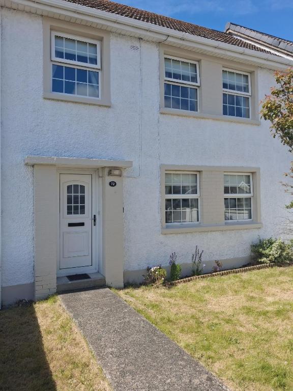 a white house with a white door and windows at Teach pádraig in Falcarragh