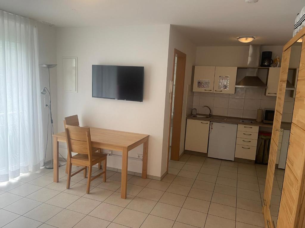 a kitchen with a table and a television on the wall at Boardinghouse Casita Amann in Friedrichshafen