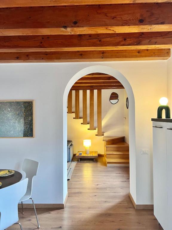 an archway leads to the kitchen and living room of a house at Casa Il Nido Bright Rooftop Nest in Lecco