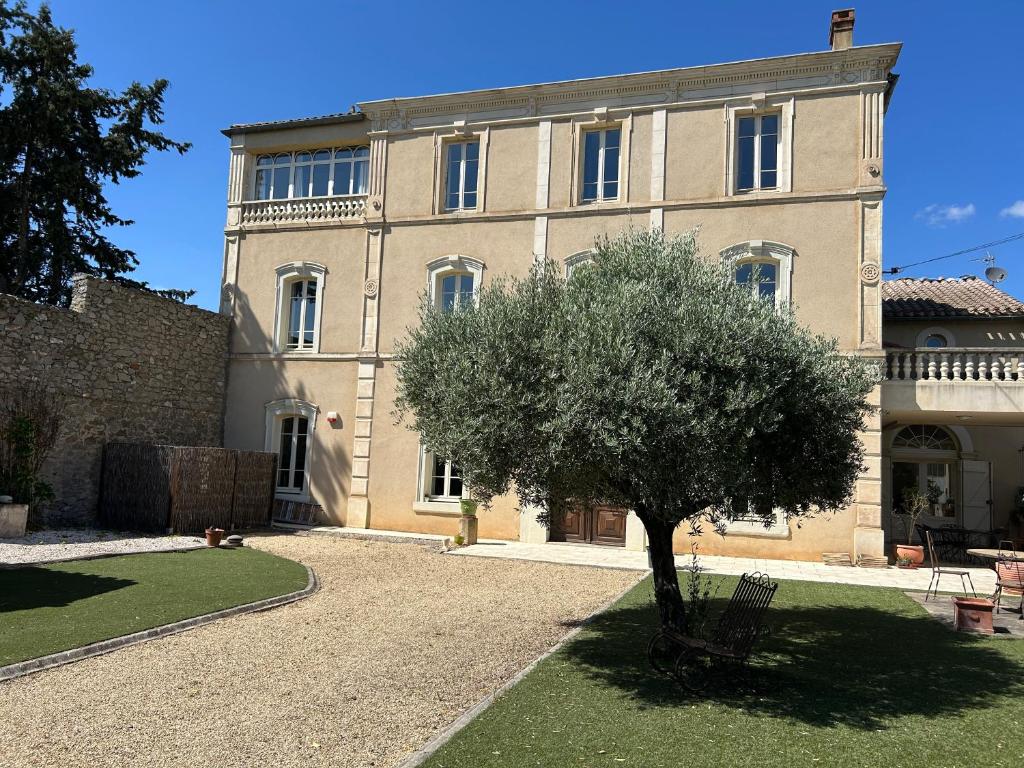 a building with a tree in front of it at La Belle Eclusière in Homps