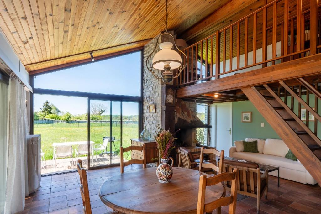 a living room with a table and a large window at Petit Clos d'Hélix in Annay-sur-Serein