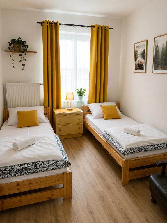 two beds in a room with a window at Powidz Work & Stay in Powidz