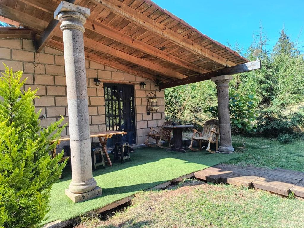 a patio with a picnic table under a roof at Cabaña Metztli in Amealco