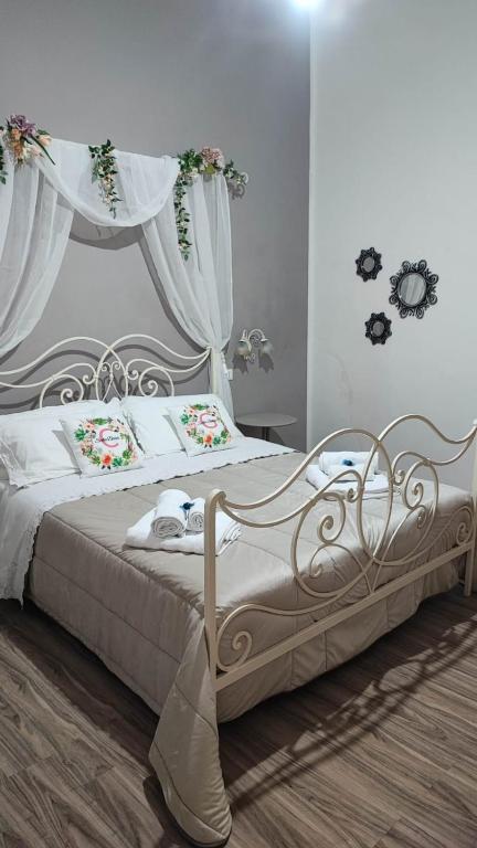a bedroom with a white bed with flowers on it at Sicilia Bedda C&G in Acireale