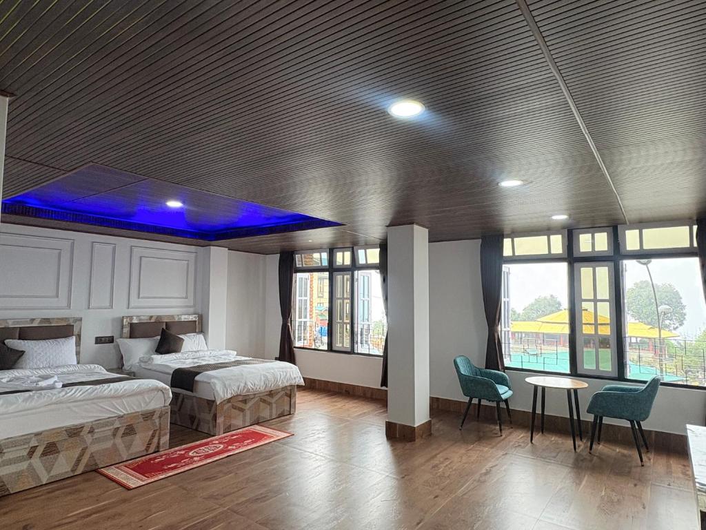a bedroom with two beds and a blue ceiling at Hotel khangyul in Ravangla