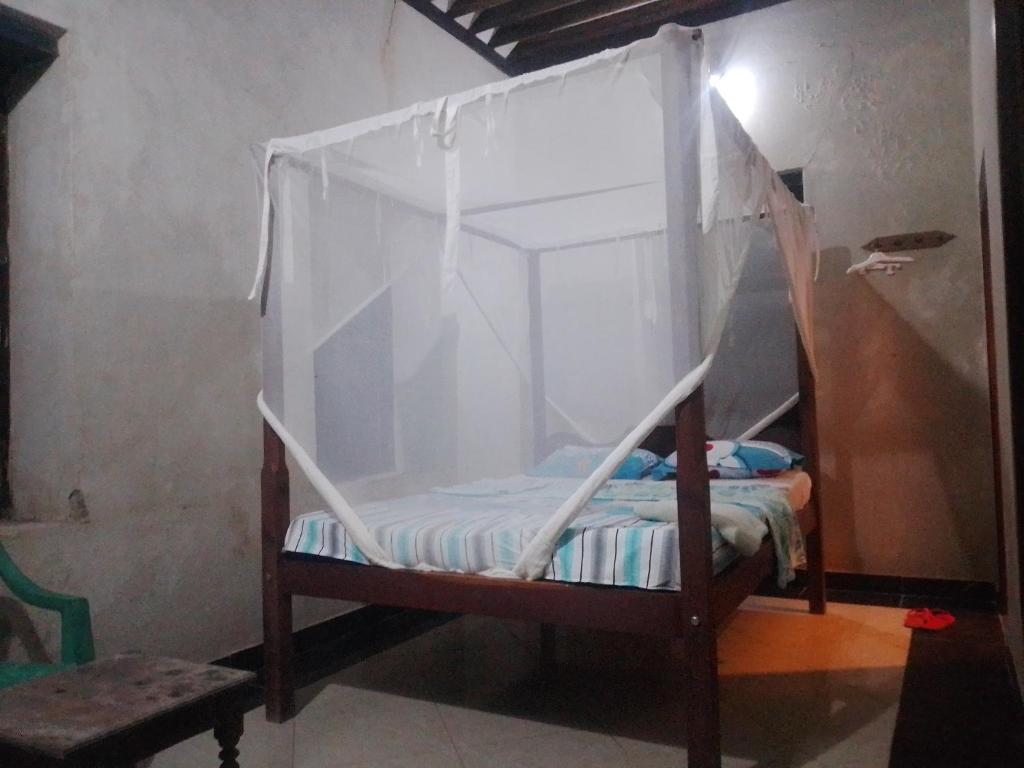 a small bed with a canopy in a room at Magram House in Lamu