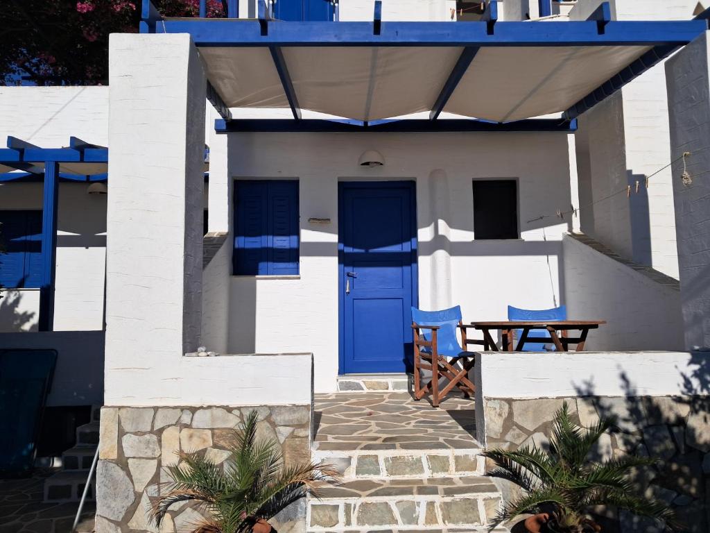 a house with a blue door and a table at Pyrgis Glyfades studios in Glifades