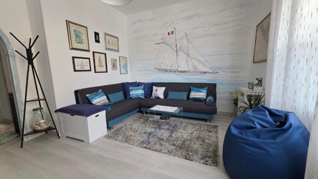 a living room with a blue couch and a boat on the wall at Giuly Sole e Sale in Le Grazie