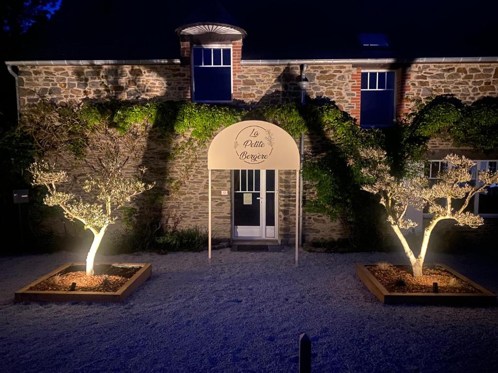 two trees with lights in front of a building at La Petite Bergère in Saint-Méloir-des-Ondes