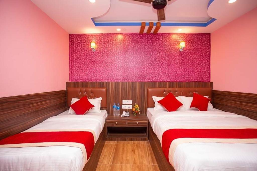 two beds in a room with pink walls at Hotel Ram Janaki in Janakpur