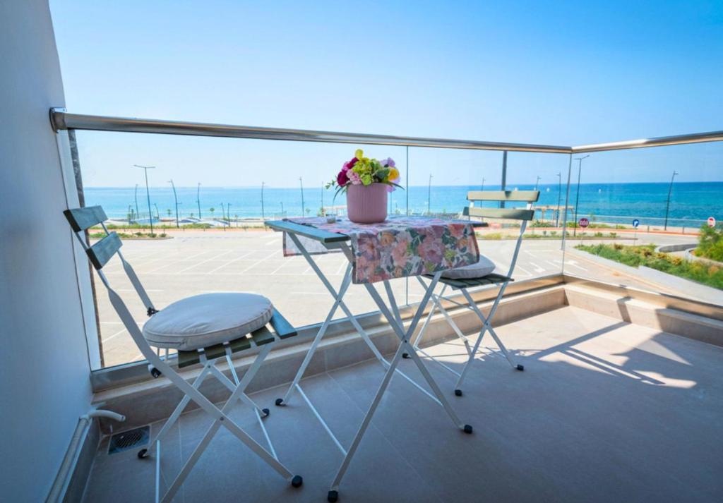 a table and two chairs on a balcony with the ocean at DeMare Suite - Nea Moudania in Nea Moudania