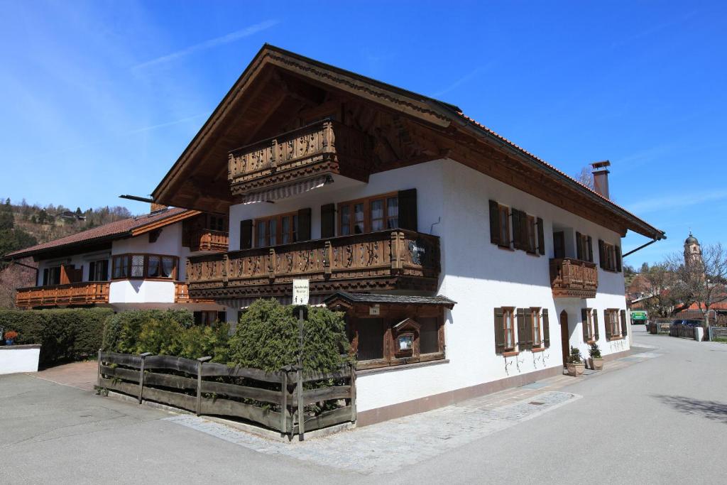 a large white building with a wooden roof at Ferienhäuser Werdenfels in Mittenwald