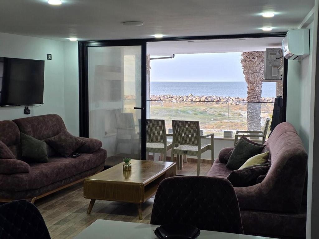 a living room with couches and a view of the ocean at Dar Julia Seaview Apartment in Mahdia