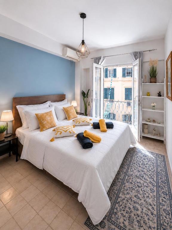 a large white bed in a room with a window at Veneziana Liston view apt in Corfu