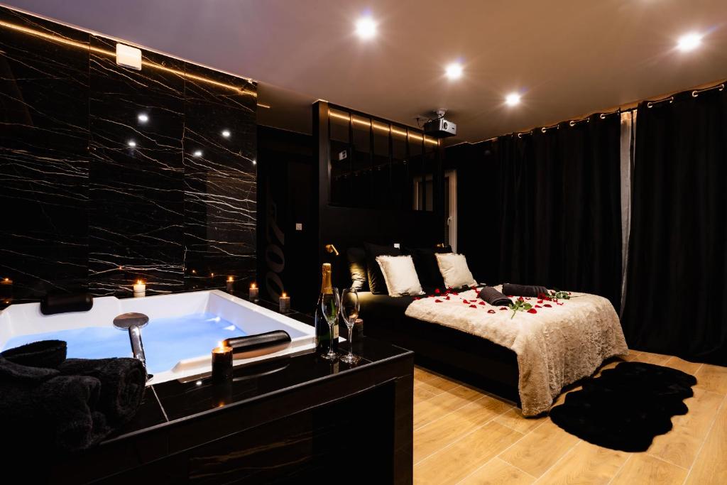 a bedroom with a bed and a bath tub at 007 Loveroom Secrète Jacuzzi privé Cinéma 4K in Courcouronnes