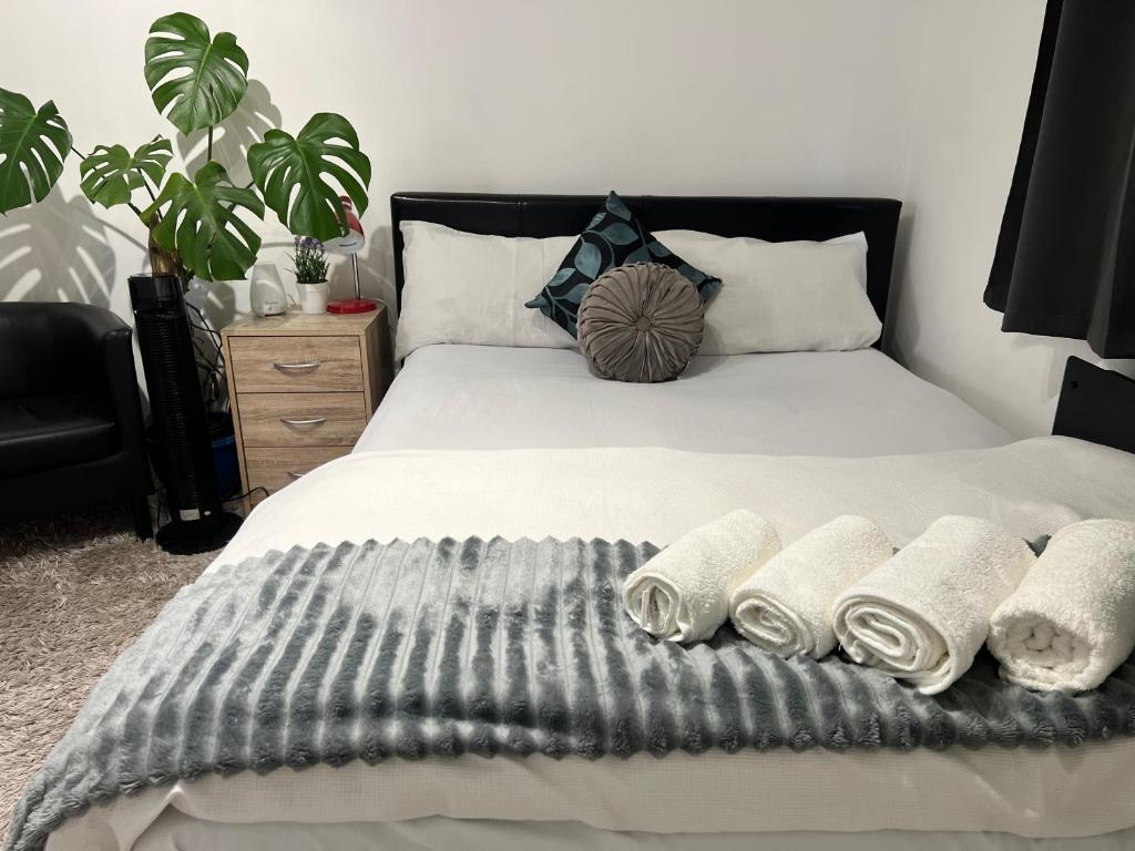 a bedroom with a bed with three towels on it at Westcliff Cottage in Southend-on-Sea