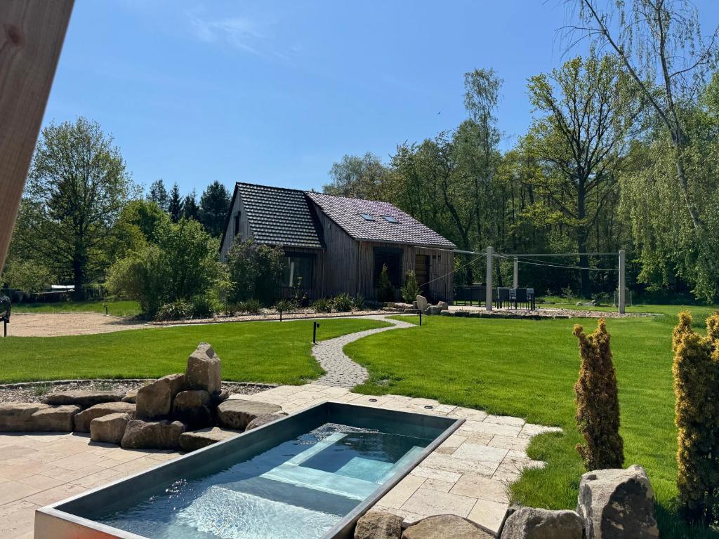 a swimming pool in a yard with a house at Foundation - Waldhaus mit Sauna & Hottub in Zittau