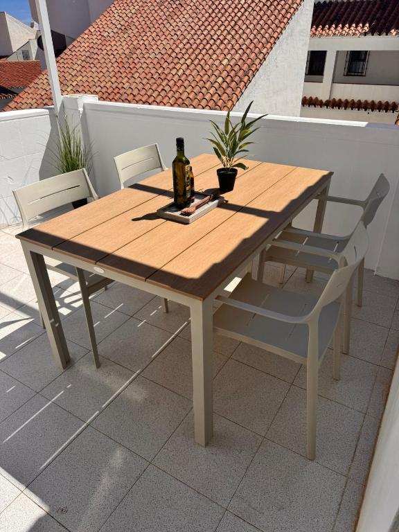 a wooden table with two chairs and a bottle of wine at Casa Feliz in Torrox Costa