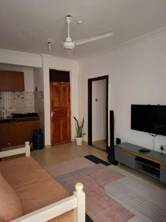 a living room with a couch and a flat screen tv at House Stark in Kilifi