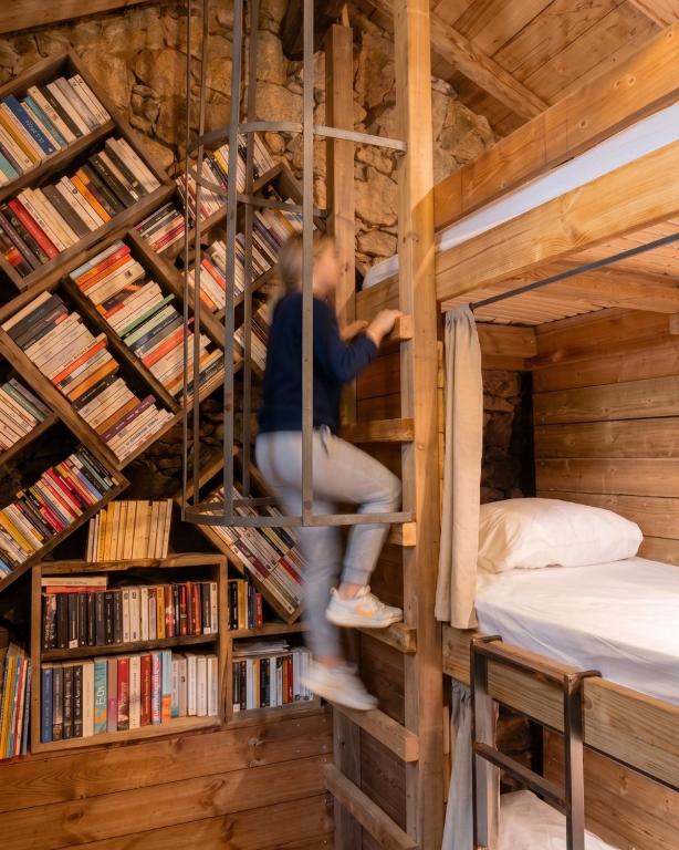 a person is sitting on a ladder in a library at Relais - U Machjonu in Tolla