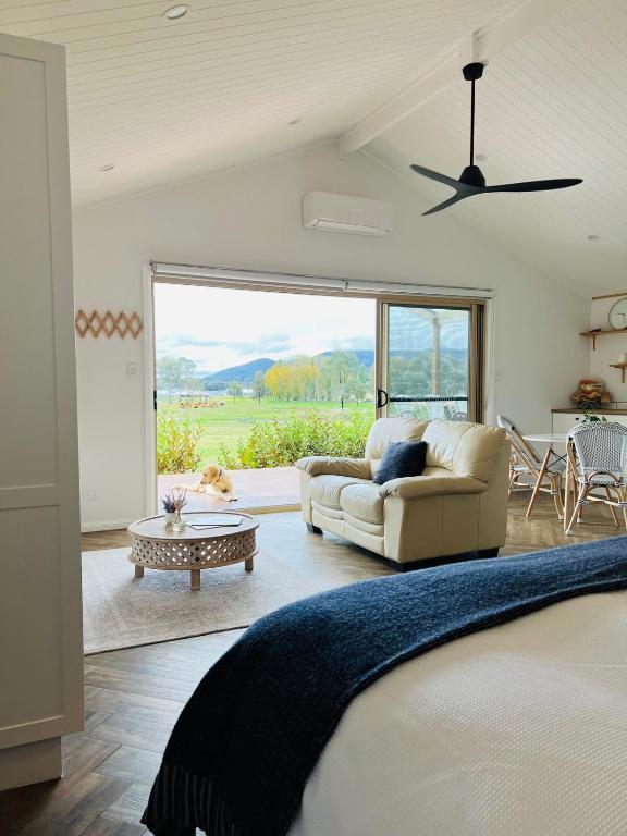 a bedroom with a bed and a couch and a table at Coco's Bungalow in Mudgee