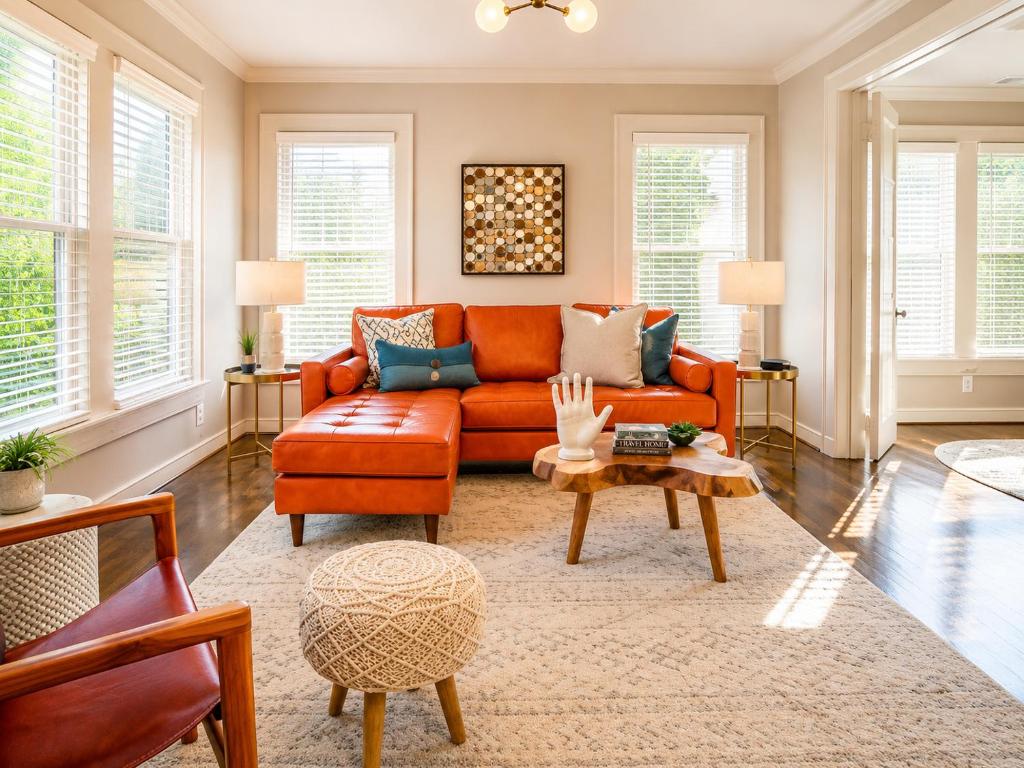 an orange couch in a living room with windows at Elevate Your Stay Chic 1-Bed Condo Courtyard in Dallas