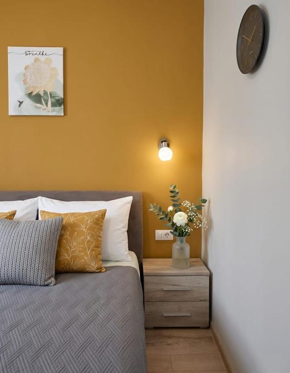 a bedroom with a bed and a clock on the wall at Apartman Mara in Risan