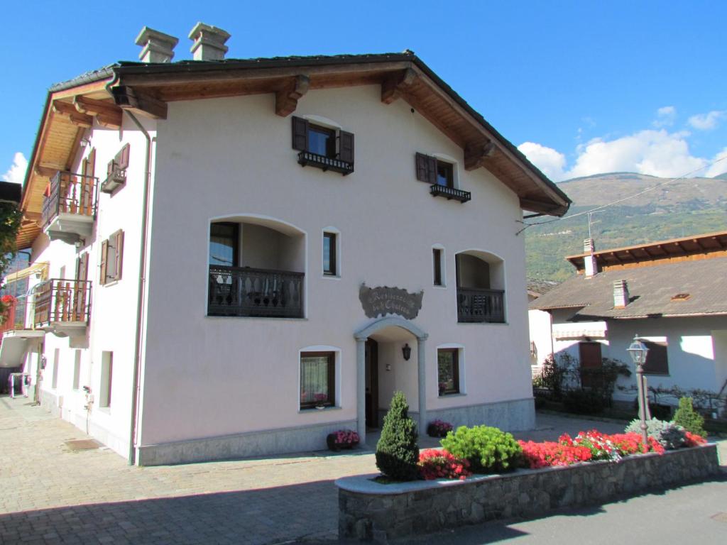 a white building with flowers in front of it at Residence Du Chateau in Fenis