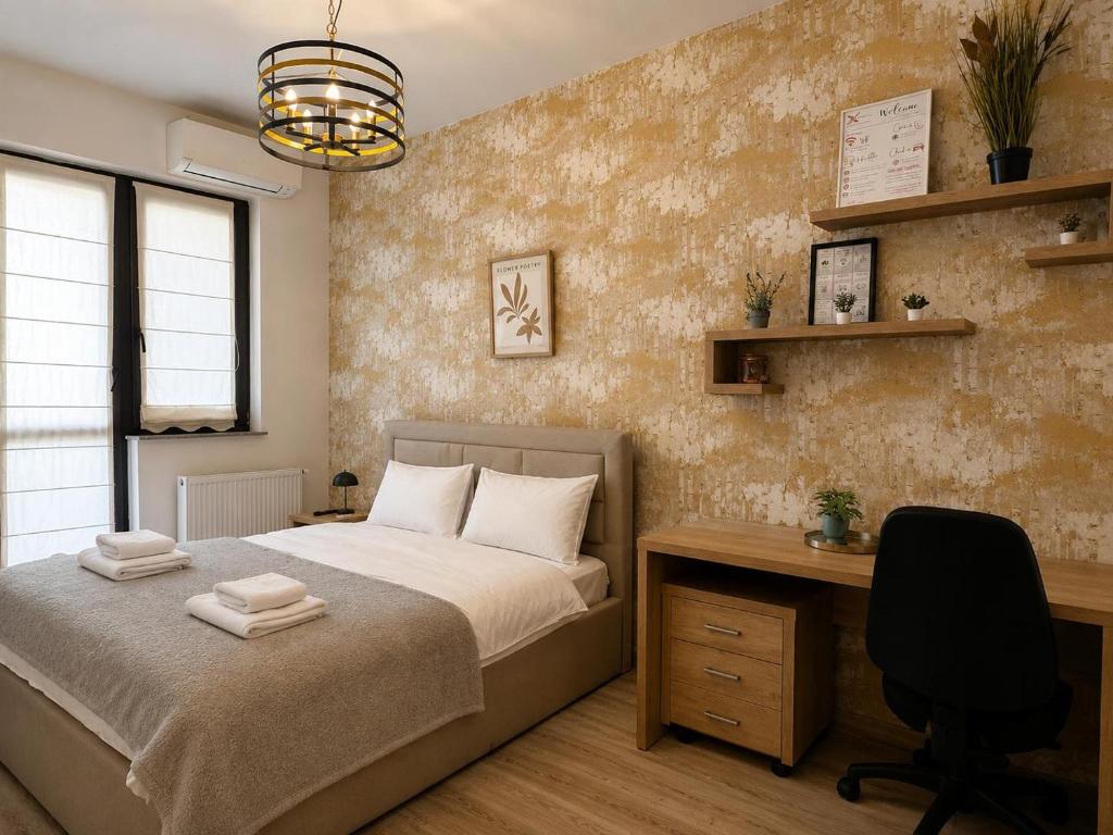 a bedroom with a bed and a desk with a chair at Studio Luxury Center in Iaşi