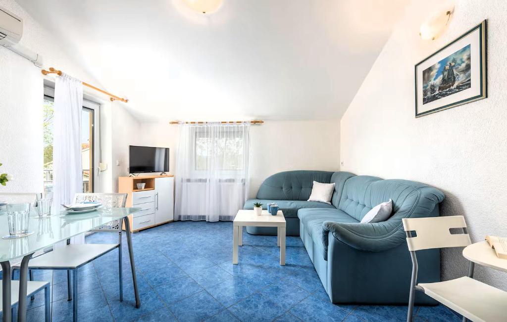 a living room with a blue couch and a table at Maja Apartment 2 in Funtana